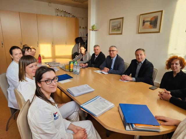 People sitting around a table in a meeting room sharing experiences