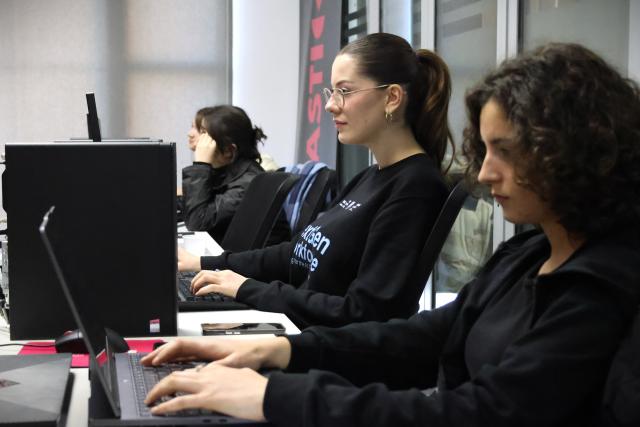 Des jeunes femmes travaillant sur des ordinateurs pour se préparer à l'ère de l'IA