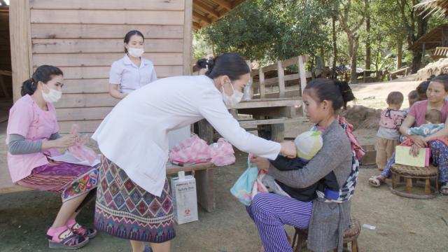 Infirmière vaccinant un enfant tenu dans les bras de sa mère