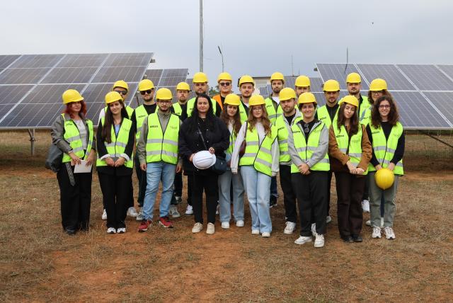 Group of technicians posing in front of solar panels