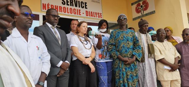 Groupe de personnes posant debout devant l'entrée d'un service hospitalier