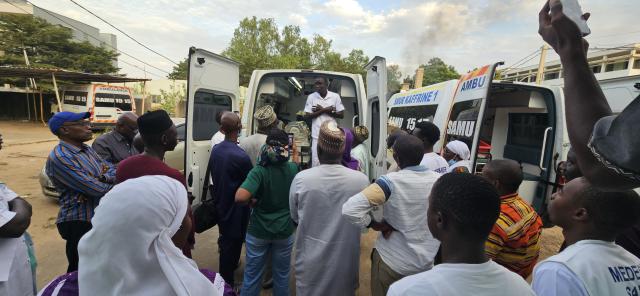 Groupe de personnes devant une ambulance