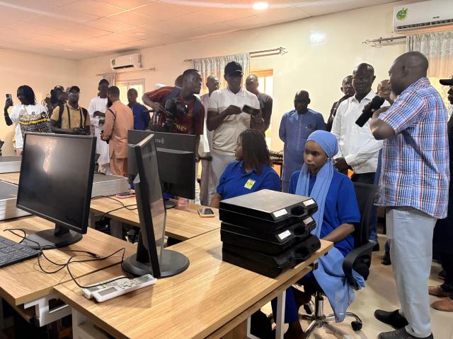 Personnes visitant une salle informatique