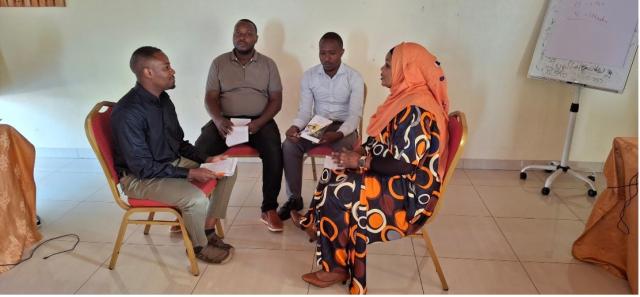 Four people sitting on chairs in circle