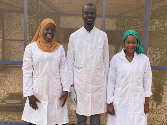 Trois personnes en blouse blanche souriant