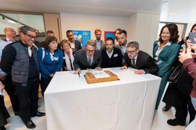 Persons blowing on candles on a birthday cake